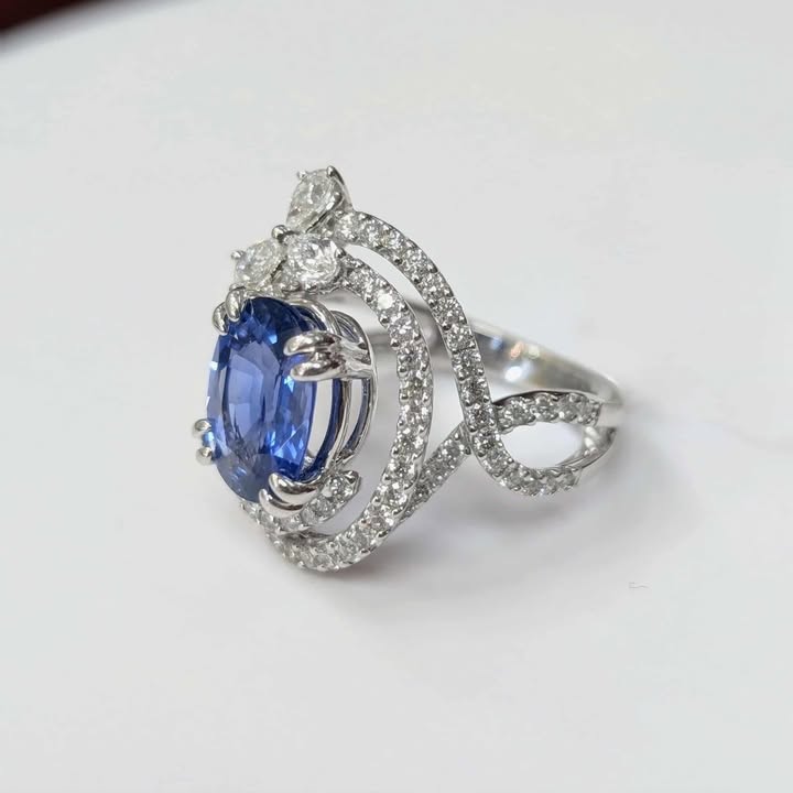 3.75 CT Oval-cut Blue Sapphire with 1.47 CT.T.W Diamond Double Swirl Frame & Three-stone Pear-cut Accent with Double Claw Prongs in 18k White Gold